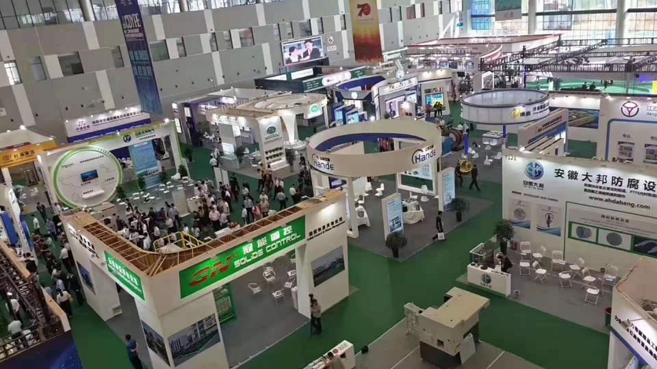 View from above of the exhibition hall with company stands and visitors.