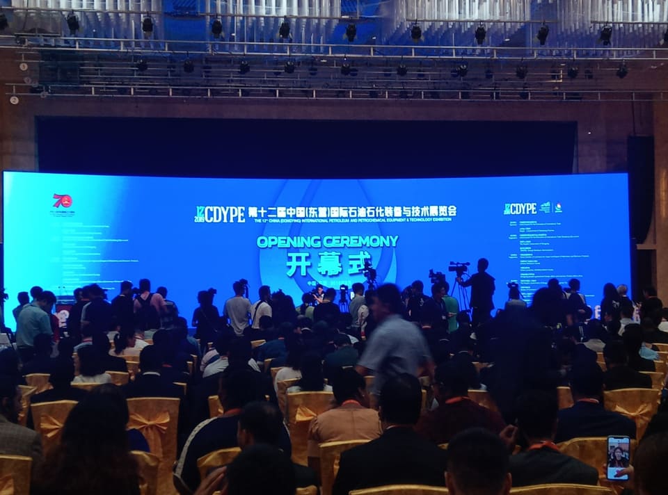 Audience in front of a large screen reading Opening Ceremony, 12th CDYPE.